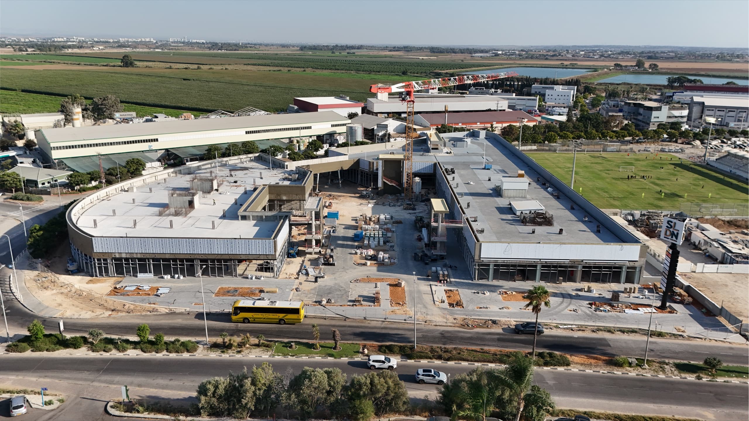 מבט על מהרחפן על טביעת הרגל המלאה של המתחם, מוקף בשדות חקלאיים, אזור תעשייה ומגרש ספורט